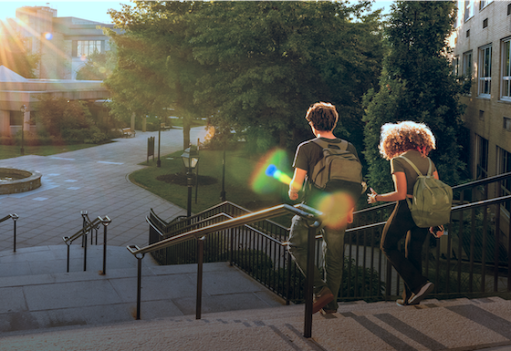 Children with rucksacks running down stairs