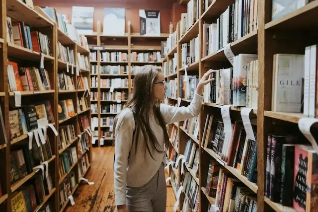 Woman looking through bookshelves.